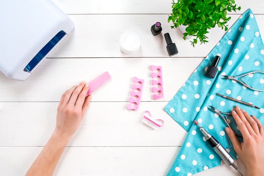 Woman Hands Care. Top View Of Beautiful Smooth Woman's Hands With Professional Nail Care Tools For Manicure On White Background. photo