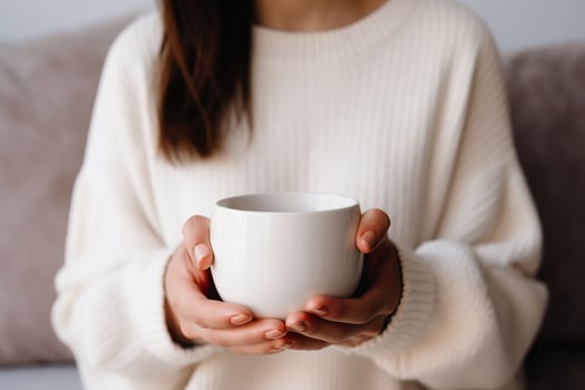 Close up of woman in white sweater holding cup of hot drink.AI Generated photo