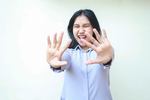 studio shot of stunned asian young beautiful business woman reaching hands towards camera smiling amazed wearing formal office shirt standing over isolated white background photo
