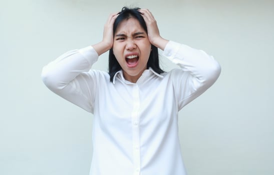 portrait of screaming asian young business woman secretary look away shouting and holding her head, female depressed for office pressure, wearing white formal shirt, standing photo