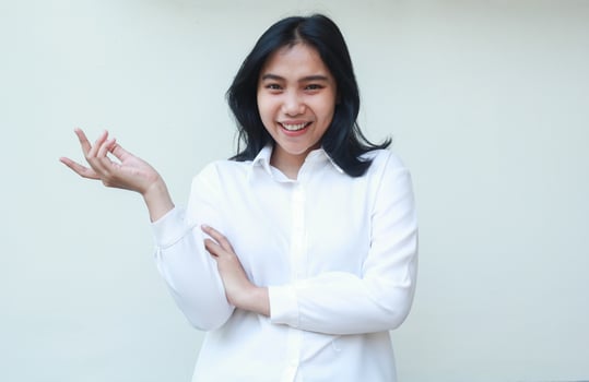 successful asia young business woman manager raising open palms to beside blank space and folded arms look at camera with confident smile wearing white formal suit shirt isolated in whte background photo