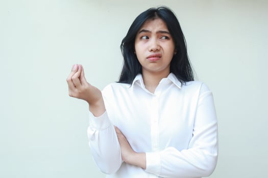 portrait of annoyed asian young business woman secretary looking aside to empty space thinking about something with raising hand curled up fingers and arms folded, standing photo