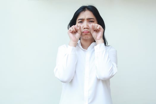pretty sad asian business woman wipe tears with hands after crying show gloomy dissatisfied expression wearing white shirt formal suit looking at camera standing over isolated background photo