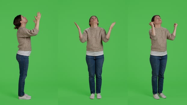 Young adult doing prayer hands symbol on full body green screen background, praying and begging to god. Religious spiritual woman hoping to receive luck or fortune, pray in silence. photo