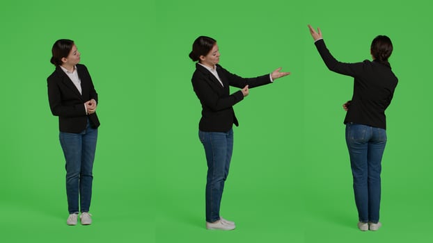Caucasian businesswoman advertising presentation sideways, doing advertisement over full body greenscreen backdrop. Office worker showing ad icon and example in studio, presenting. photo