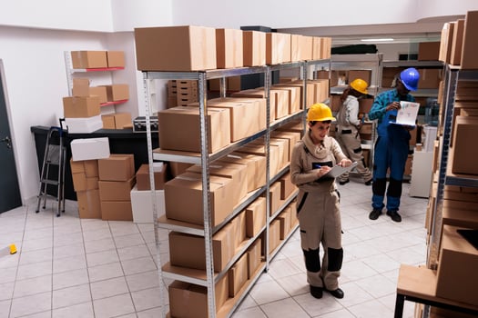 Factory warehouse managers diverse team making goods inventory, checking export report analytics. Storehouse man and woman supervisors working in stockroom and managing dispatching photo