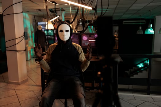 Ransomware, internet blackmail, scammer recording threat video on smartphone, asking victim money for ransom. Anonymous in mask stealing information online, computer fraud photo