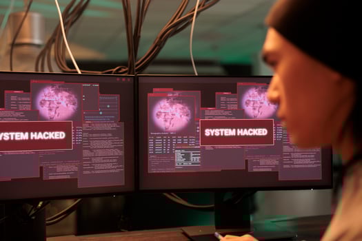 Asian thief analyzing encryption alert on monitors, working to break into government system late at night. Young person planting malware to crack security code, stealing passwords. photo