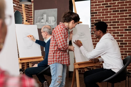 Two diverse young people man and woman friends drawing together during group art class, smiling and enjoying creative activities. Couple enjoy artistic date. Hobbies for socializing photo