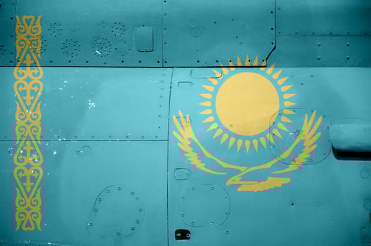 Kazakhstan flag depicted on side part of military armored helicopter closeup. Army forces aircraft conceptual background photo