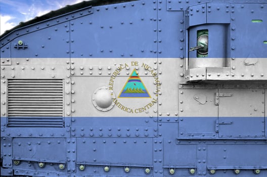 Nicaragua flag depicted on side part of military armored tank closeup. Army forces conceptual background photo