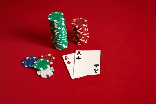 Poker chips and aces on red background. Group of different poker chips. Casino background. photo