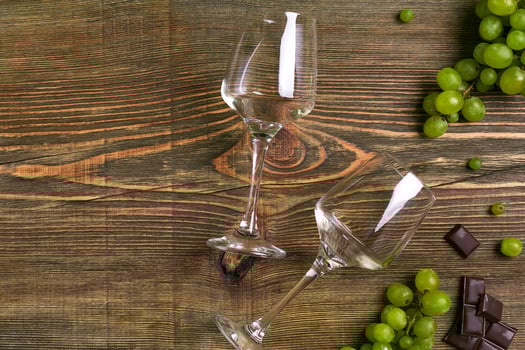Glasses of wine and ripe grapes isolated on a wooden table photo