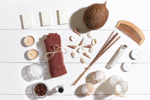 Spa set with sea salt, essential oil, soap and towel decorated with seashells on white wooden background photo
