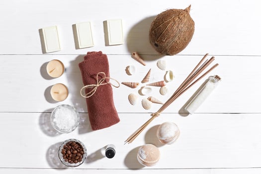 Spa set with sea salt, essential oil, soap and towel decorated with seashells on white wooden background photo