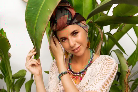 Woman with bright make up in bohemian outfit, turban, ethnic earrings, necklace and bracelets posing in swimming pool. photo