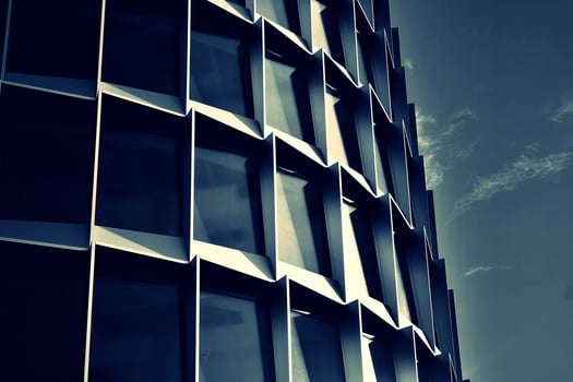 Modern office building with glass facade on a clear sky background. Transparent glass wall of office building. photo