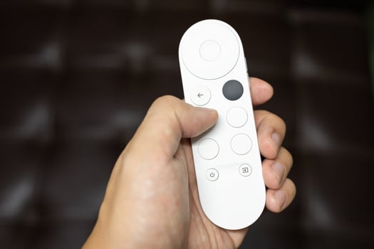 Hand holding modern remote for control watching tv. photo