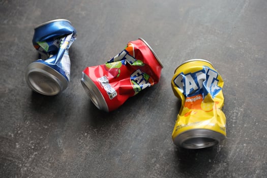 KYIV, UKRAINE - 4 MAY, 2023 Fanta soft drink brand crumpled tin cans with various flavours photo