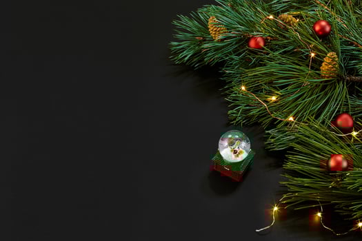 Christmas. Xmas toys and spruce branch on black background top view. Copy space. photo