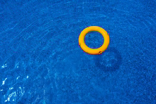 Top view of lifebuoy floating in blue swimming pool, soft focus. photo