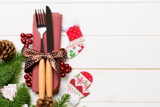 Top view of festive cutlery on new year wooden background. Christmas decorations with empty space for your design. Holiday dinner concept photo