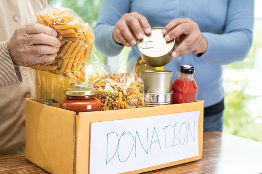 Volunteers putting various dry food in donation box for help people. photo