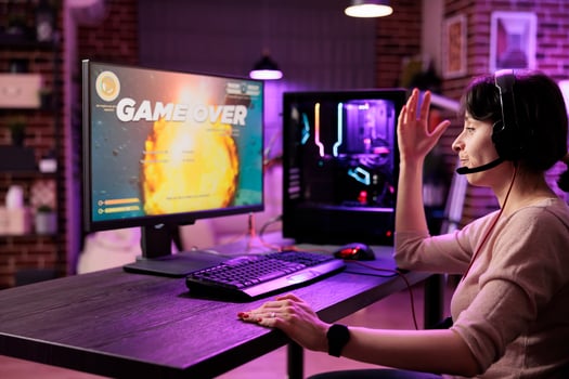 Frustrated gamer losing singleplayer spaceship arcade racing videogame, seeing game over screen on gaming computer display. Woman being dissapointed after being defeated on difficult game level photo