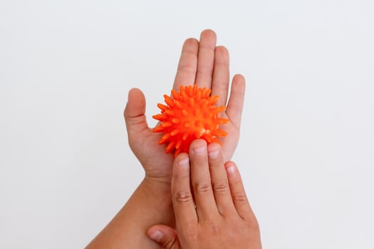 Cropped child hands doing exercise using spiky ball photo