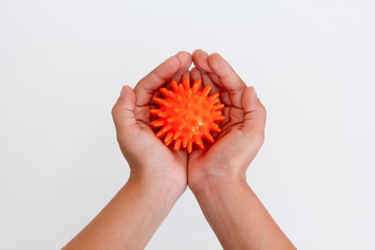 Child hands holding orange spiky ball for massage photo