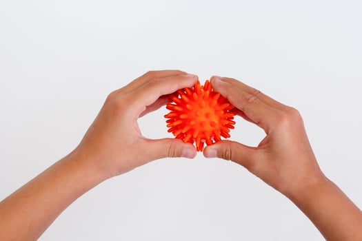 Cropped child hands doing exercise using spiky ball photo