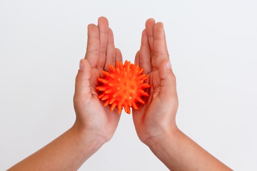 Child hands holding orange spiky ball for massage photo