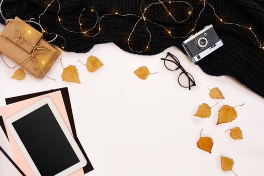 Autumn concept, dried fall leaves, mug of cocoa, old camera, scarf and tablet with blank screen. Mock up photo