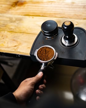 Coffee espresso tamper. Barista preparing to apply pressure on coffee tamper. Preparation of tamping tamp press on ground coffee to make an espresso. photo