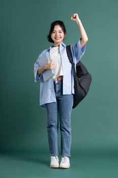 Portrait of a beautiful Asian student on a green background photo