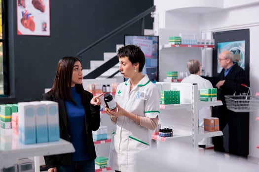 Customer returning vitamin bottle to pharmacist in drugstore, complaining about supplements quality. Young asian woman and confused pharmaceutical assistant talking about multivitamin in apothecary photo