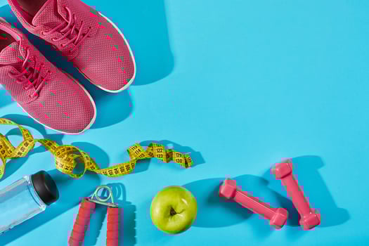 Sneakers with measuring tape on cyan blue background. Sport shoes and sportive equipment for healthy shape. photo
