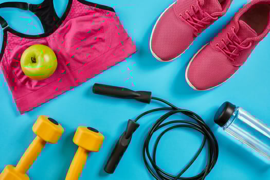 Athlete's set with female clothing, dumbbells and bottle of water on bright blue background photo