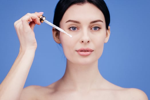 Close up of woman body care at home. Portrait of woman applying moisturizer cream on neck. Natural skin care photo