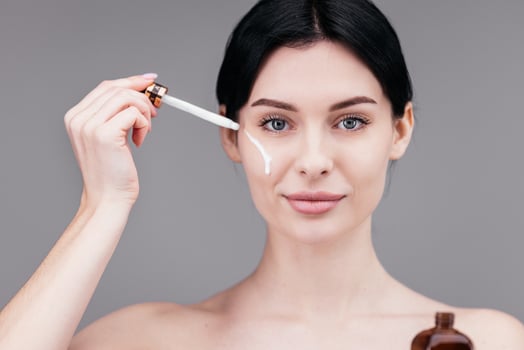 Close up of woman body care at home. Portrait of woman applying moisturizer cream on neck. Natural skin care photo
