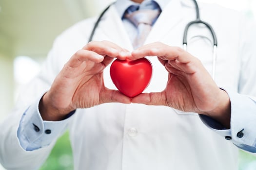 Asian woman doctor holding red heart for health in hospital. photo