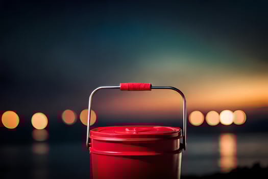 a red bucket sitting on the ground near the water. AI-Generated photo