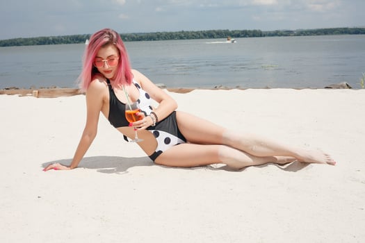 Young cheerful woman in swimsuit, toasting with cocktail, drinking fresh photo