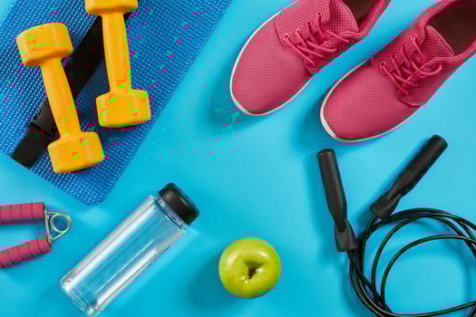 Athlete's set with female clothing, dumbbells and bottle of water on bright blue background photo