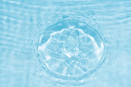 Defocus blurred transparent blue colored clear calm water surface texture with splashes reflection. Trendy abstract nature background. Water waves in sunlight with copy space. Blue watercolor shine. photo
