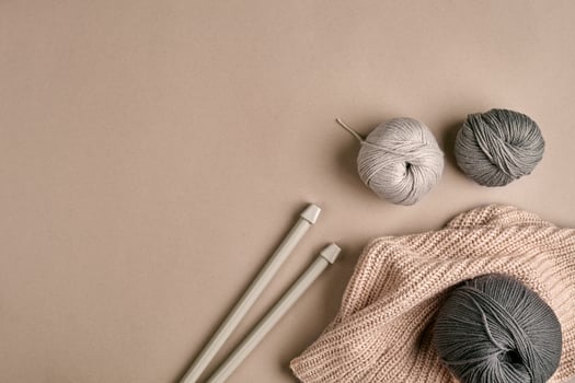 Knitted from a gray yarn sweater and thread for knitting closeup. Knitting as a hobby. Accessories for knitting. photo