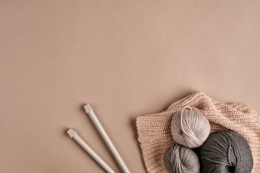 Knitted from a gray yarn sweater and thread for knitting closeup. Knitting as a hobby. Accessories for knitting. photo