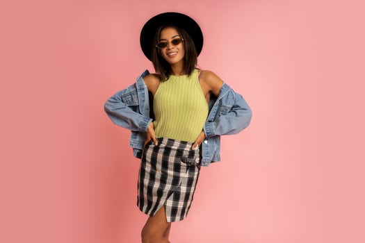 Nice smiling stylish woman in spring outfit posing over pink backgrond in studio. photo