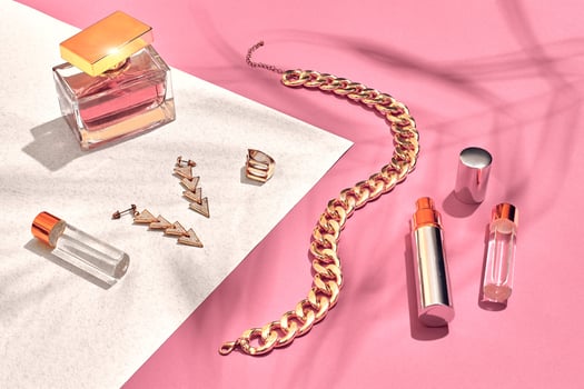 Fashionable Women's Cosmetics and Accessories. Flat Lay. Perfume. Pink and white background. Shadow from a palm leaf photo