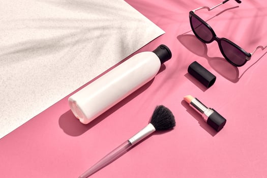 Woman's accessories lying flat on textured paper background. Pink and white pastel colors with copy space around products. photo